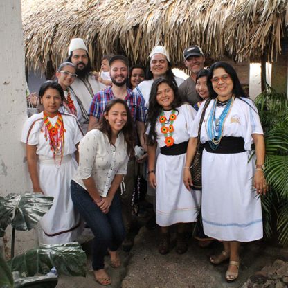 A coffee producing family in Colombia dressed in traditional white clothing with brightly coloures beaded necklaces