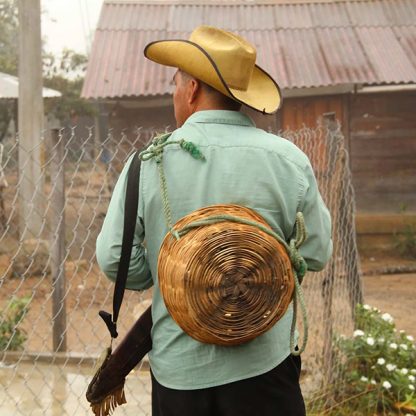 A coffee farmer from Mexico Chiapas posing with a woven basket